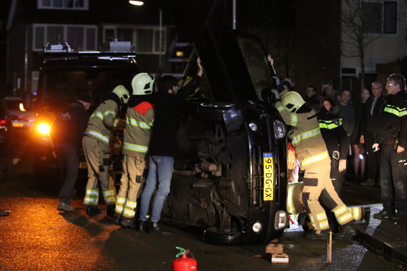 Bestuurster bekneld na auto op zijn kant