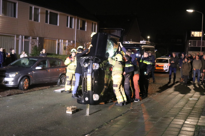 Bestuurster bekneld na auto op zijn kant