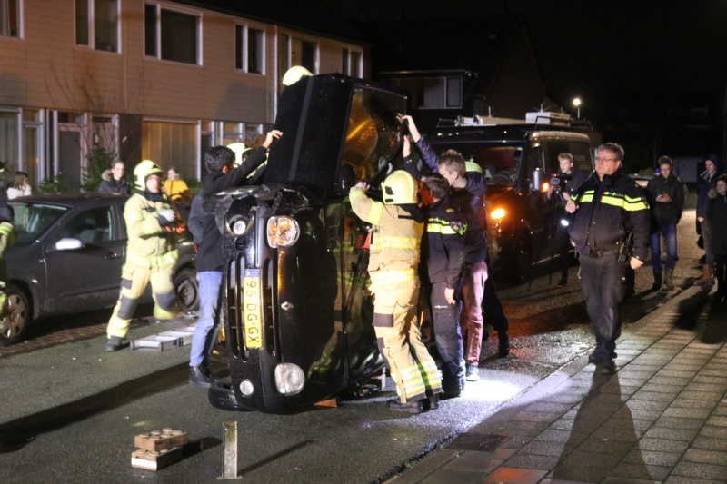 Bestuurster bekneld na auto op zijn kant