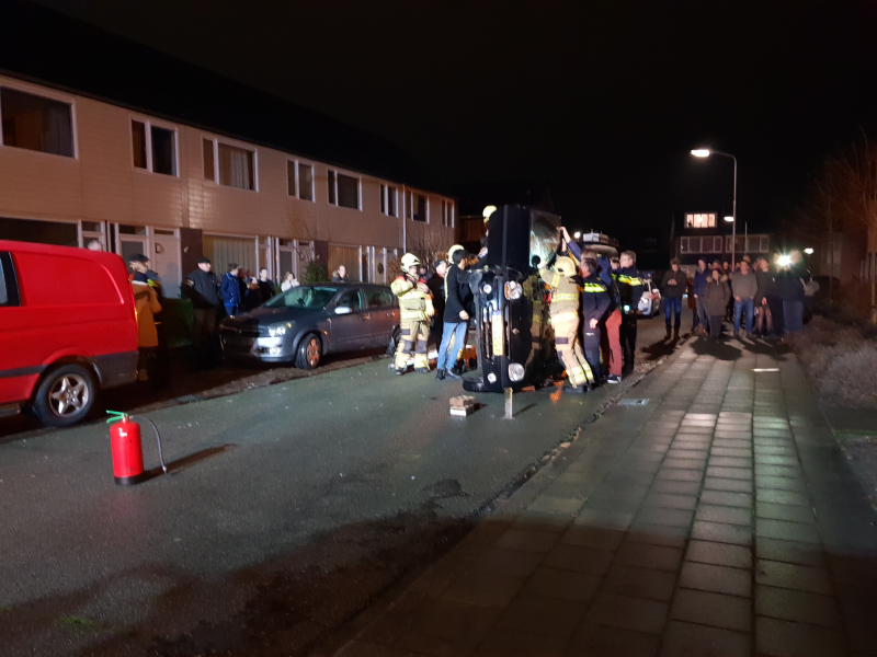 Bestuurster bekneld na auto op zijn kant