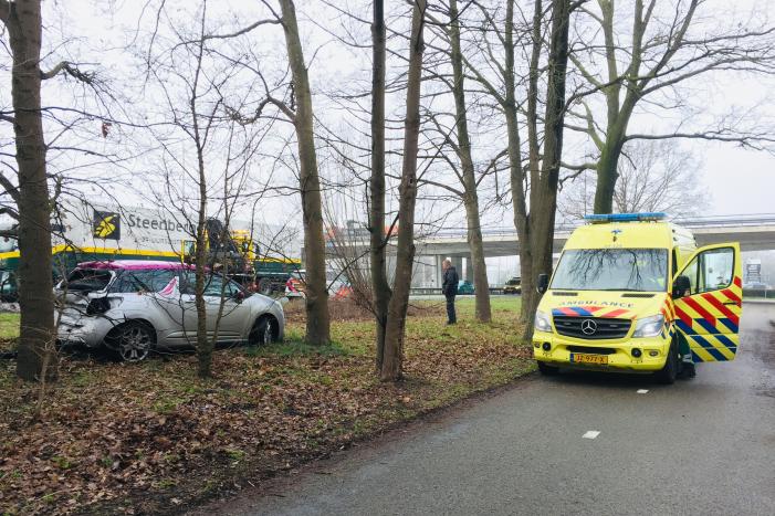 Auto belandtt in bosschages na aanrijding met vrachtwagen