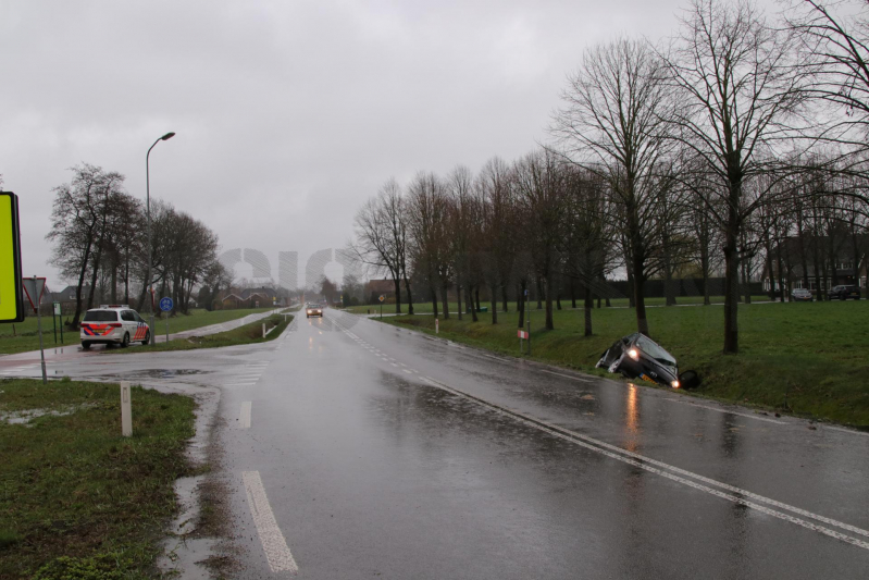 Auto schiet over kruising de sloot in