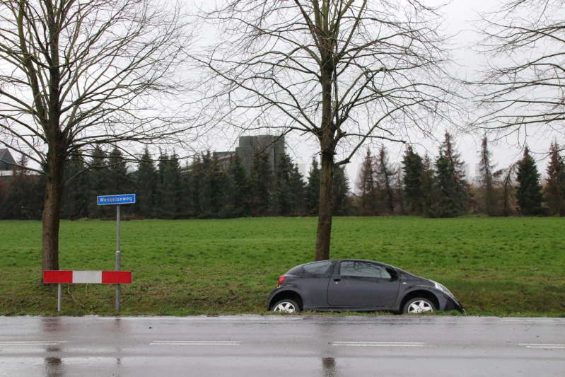 Auto schiet over kruising de sloot in