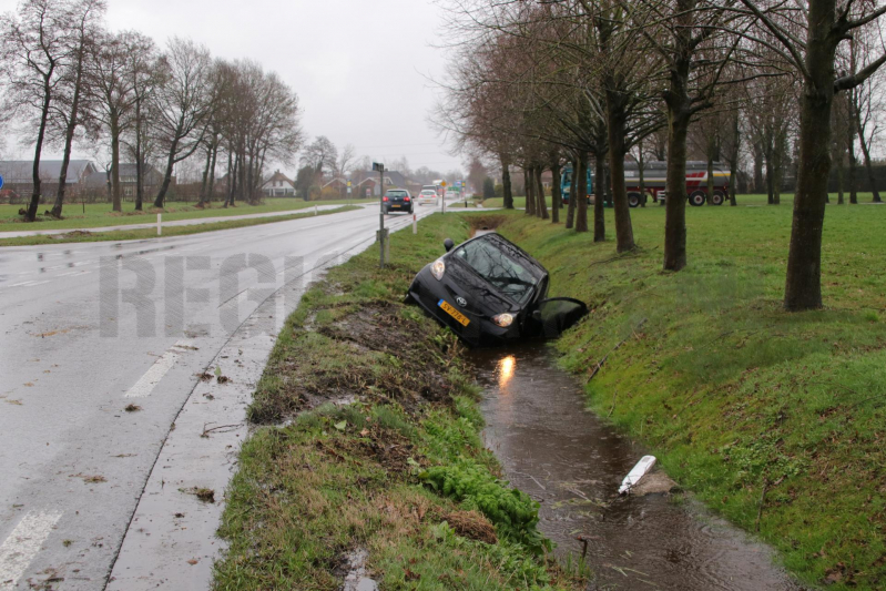 Auto schiet over kruising de sloot in