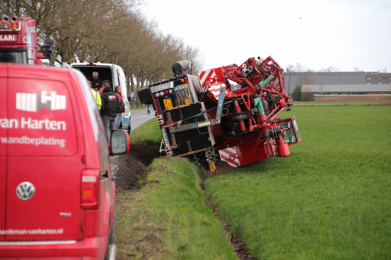 Kraanwagen belandt in weiland