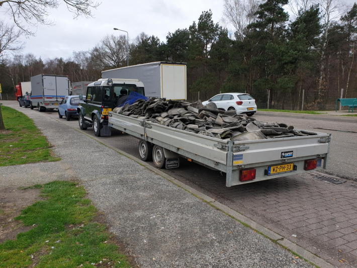 Auto met zware aanhanger dakpannen belandt in vangrail