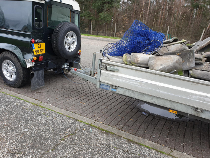 Auto met zware aanhanger dakpannen belandt in vangrail