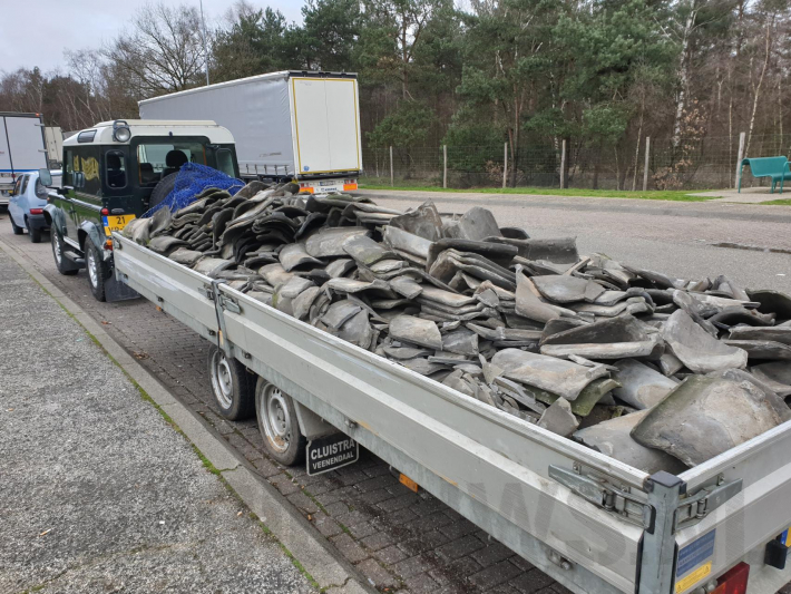 Auto met zware aanhanger dakpannen belandt in vangrail