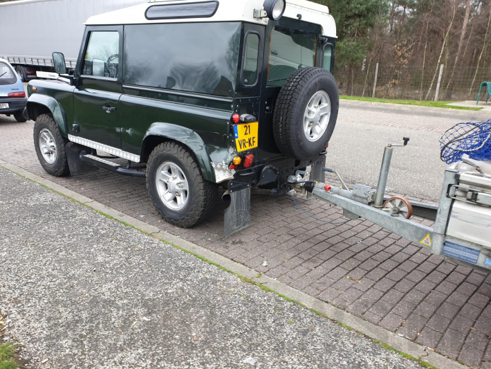 Auto met zware aanhanger dakpannen belandt in vangrail