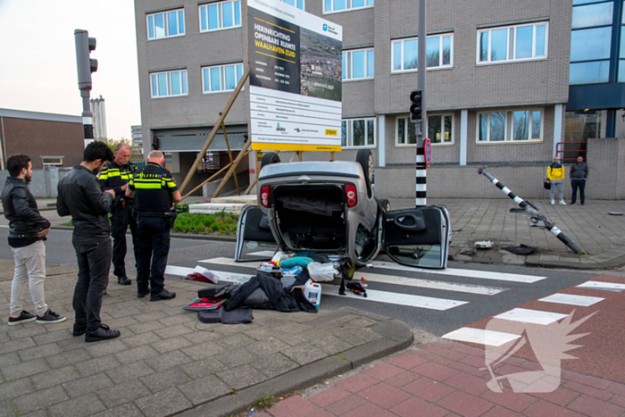 Automobilist over de kop na rammen stoplicht
