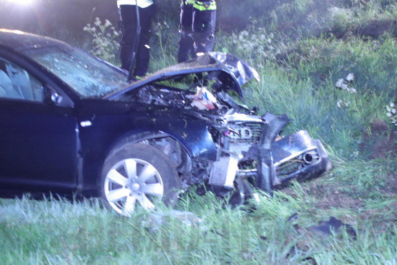 Auto belandt naast de snelweg