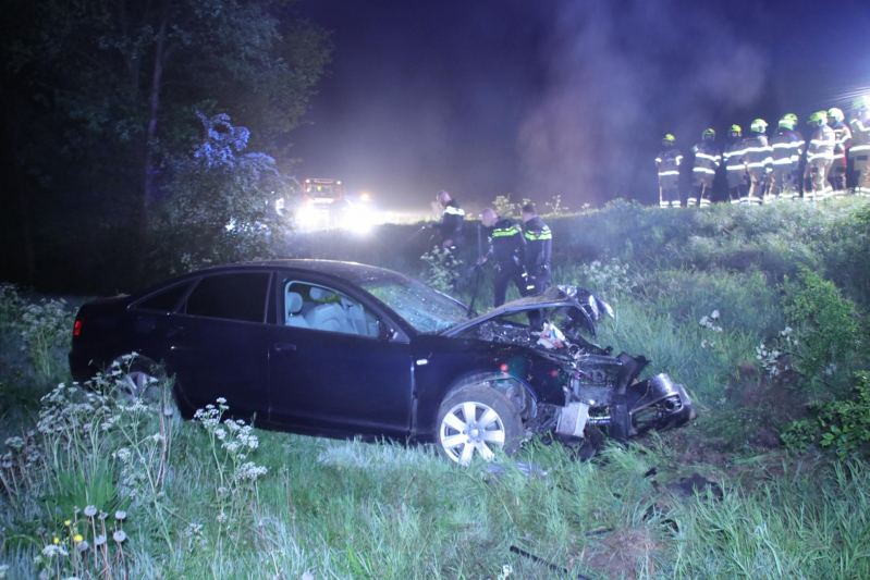 Auto belandt naast de snelweg