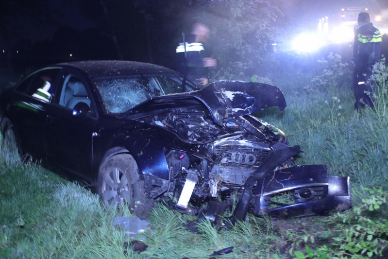 Auto belandt naast de snelweg