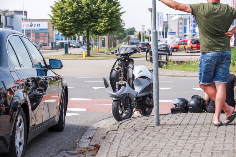 Overstekende brommer botst op auto