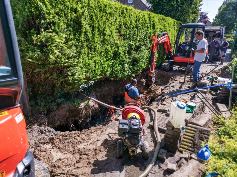 Smalle weg afgesloten door gesprongen waterleiding