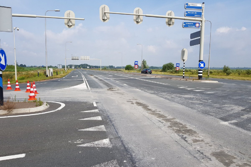 Weg afgesloten door bagger op wegdek