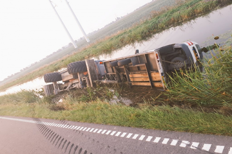 Graafmachine met aanhanger belandt te water