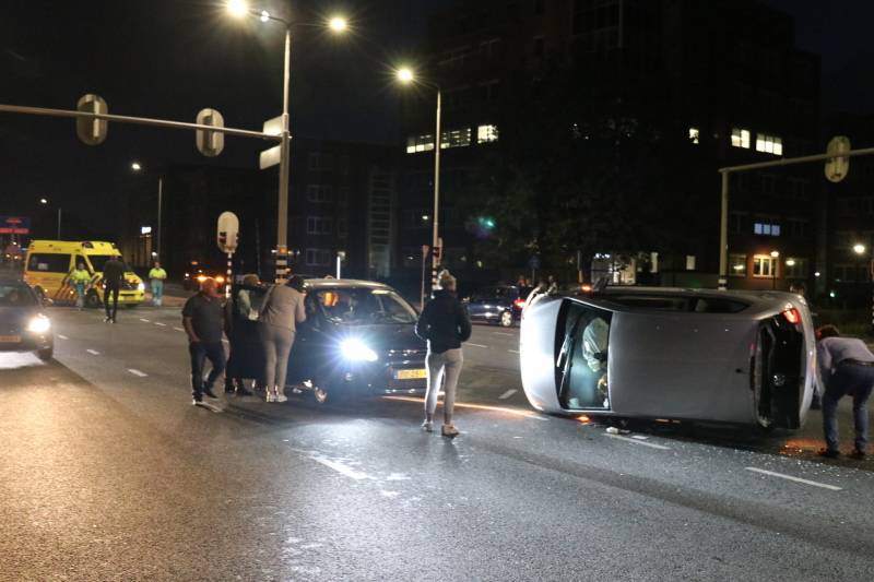 Auto belandt op zijkant na botsing; inzittende gewond bij reddingsactie