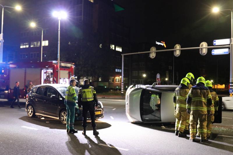 Auto belandt op zijkant na botsing; inzittende gewond bij reddingsactie