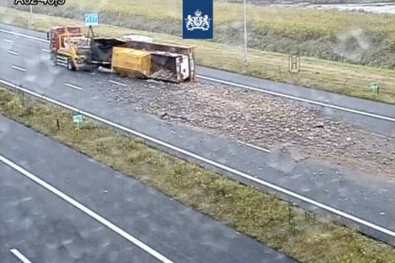 Aanhanger met bakstenen en puin gekanteld op snelweg