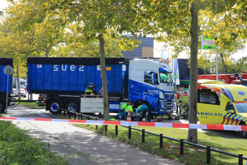 Afslaande vrachtwagen rijdt over fietsster