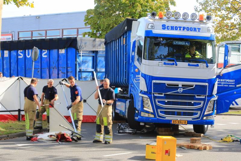 Afslaande vrachtwagen rijdt over fietsster
