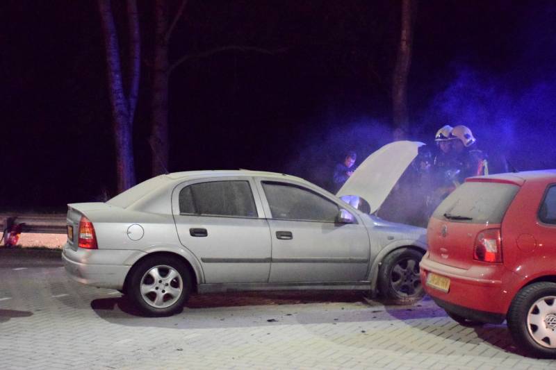 Omstanders blussen brandende auto