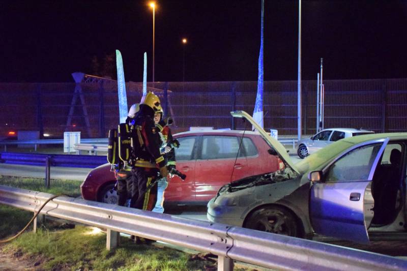 Omstanders blussen brandende auto