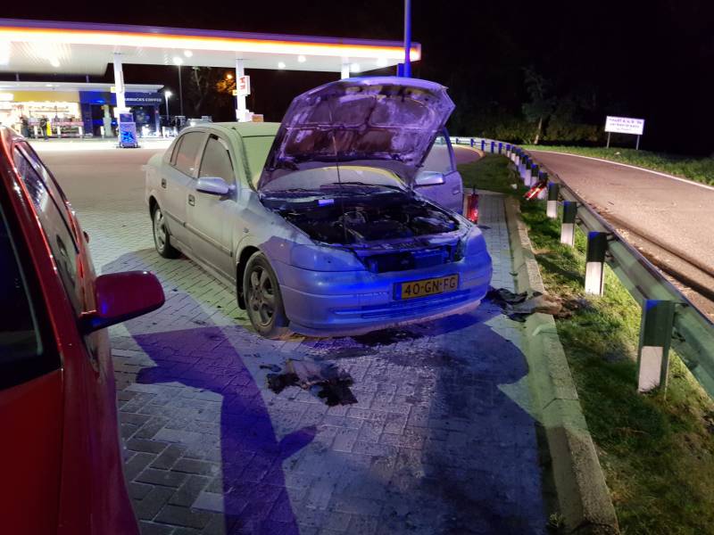 Omstanders blussen brandende auto