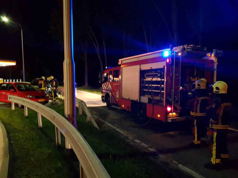 Omstanders blussen brandende auto