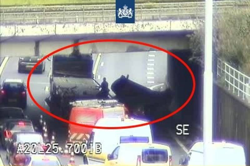 Vrachtwagen met hoogwerker klemgereden onder spoorviaduct