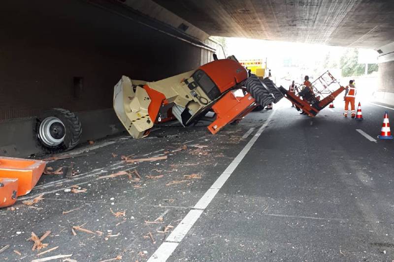 Vrachtwagen met hoogwerker klemgereden onder spoorviaduct