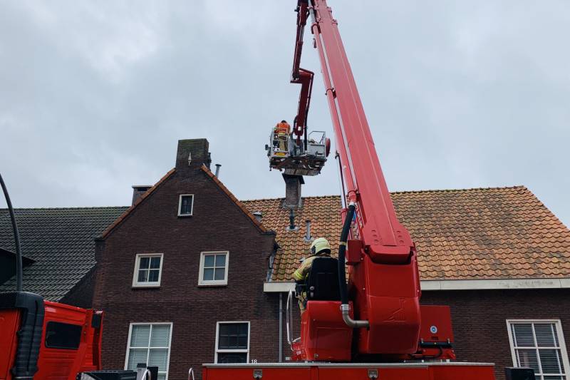 Brandweer veegt schoorsteen na brand