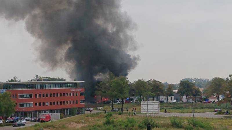 Auto in garagebedrijf in brand
