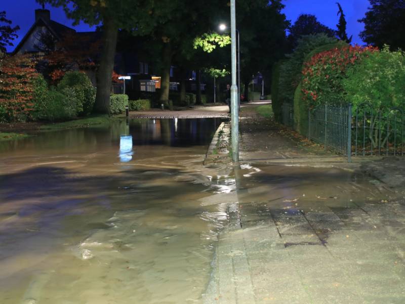 Straat blank door gesprongen waterleiding