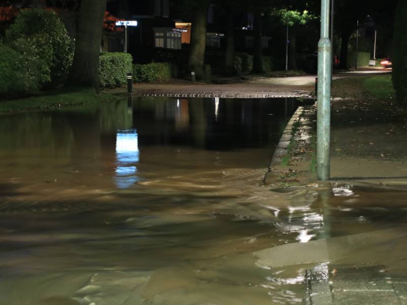 Straat blank door gesprongen waterleiding