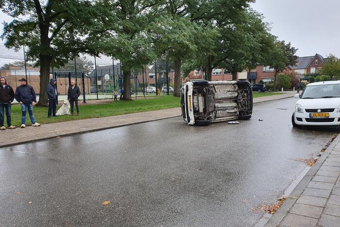 Auto belandt op zijn kant na aanrijding in woonwijk