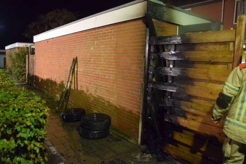 Auto met vloeistof besmeurd, schutting in brand gestoken