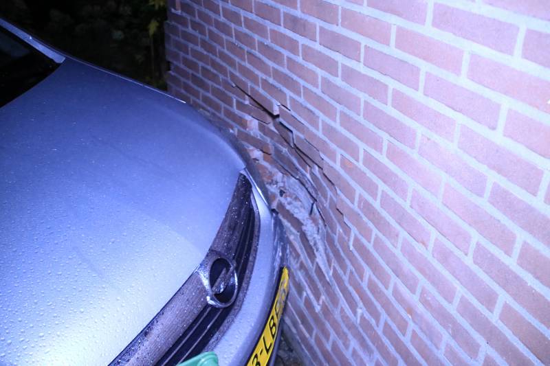 Geparkeerde auto ramt gevel na aanrijding