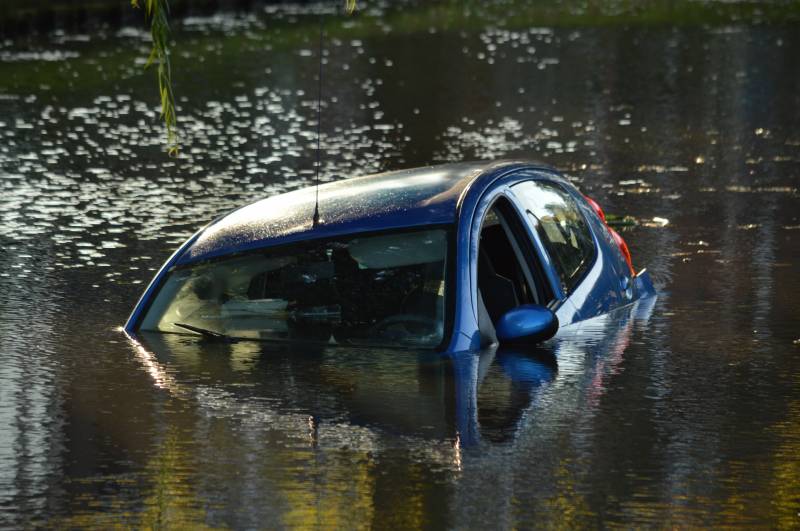 Automobilste rijdt met auto water in