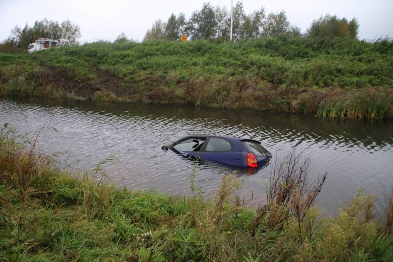 Bestuurder klimt op dak van te water geraakte auto
