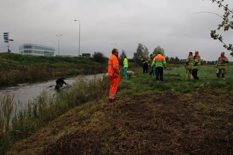 Bestuurder klimt op dak van te water geraakte auto