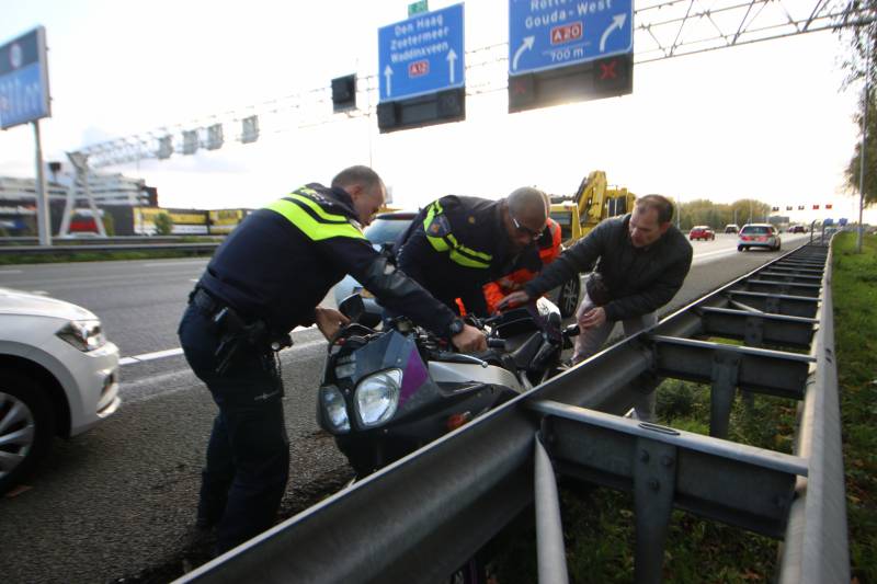 Motor belandt onder vangrail, bestuurder gewond