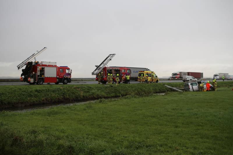 Bestelbus belandt in sloot naast snelweg
