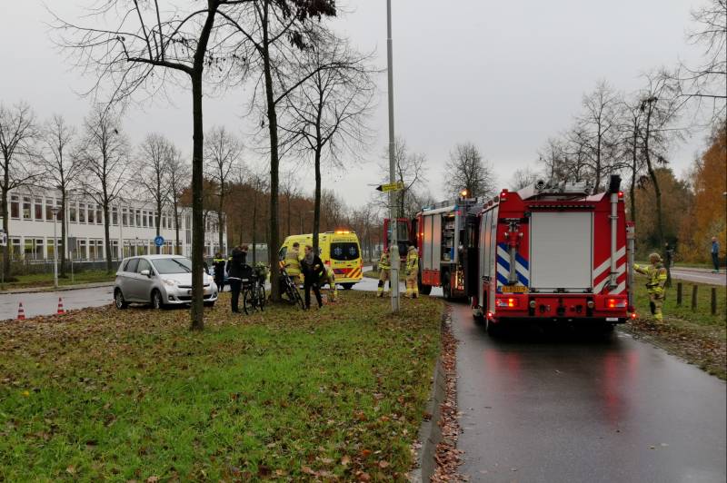Fietser bekneld onder auto