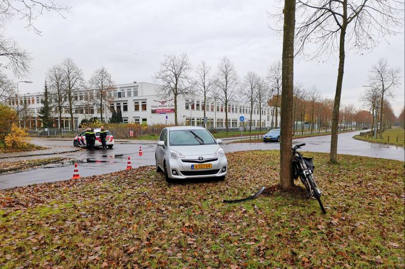 Fietser bekneld onder auto