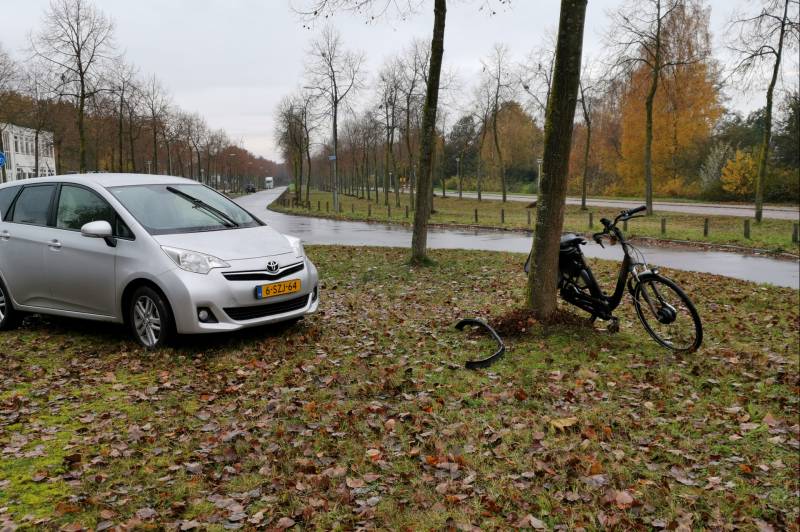 Fietser bekneld onder auto