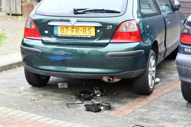 Persoon bekneld onder auto