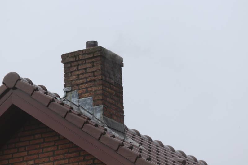 Brandweer veegt schoorsteen na brand