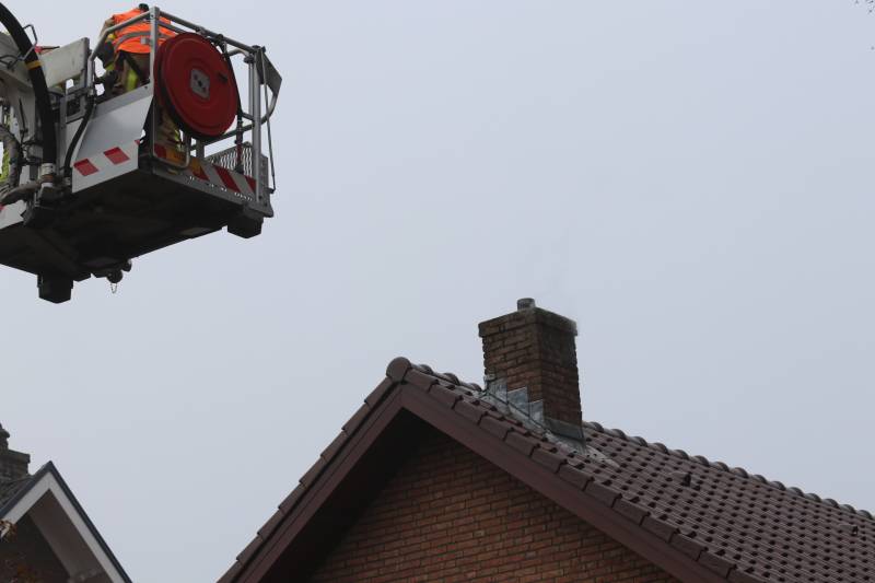 Brandweer veegt schoorsteen na brand